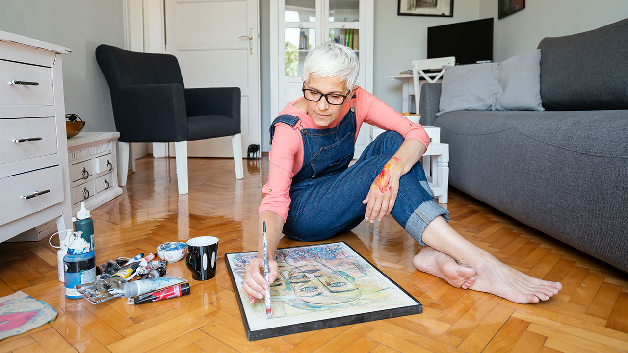 Woman on floor painting a picture