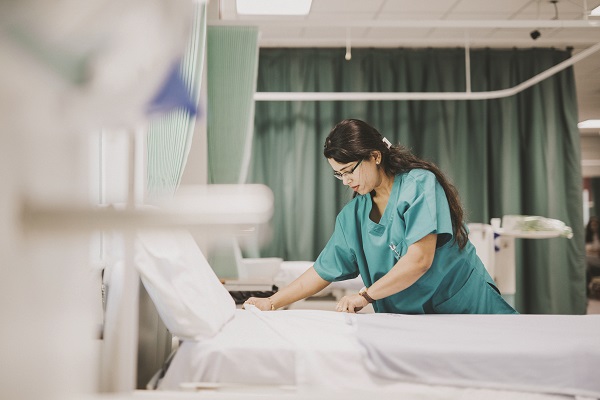 Nurse making the bed at a hospital Nurse making the bed at a hospital