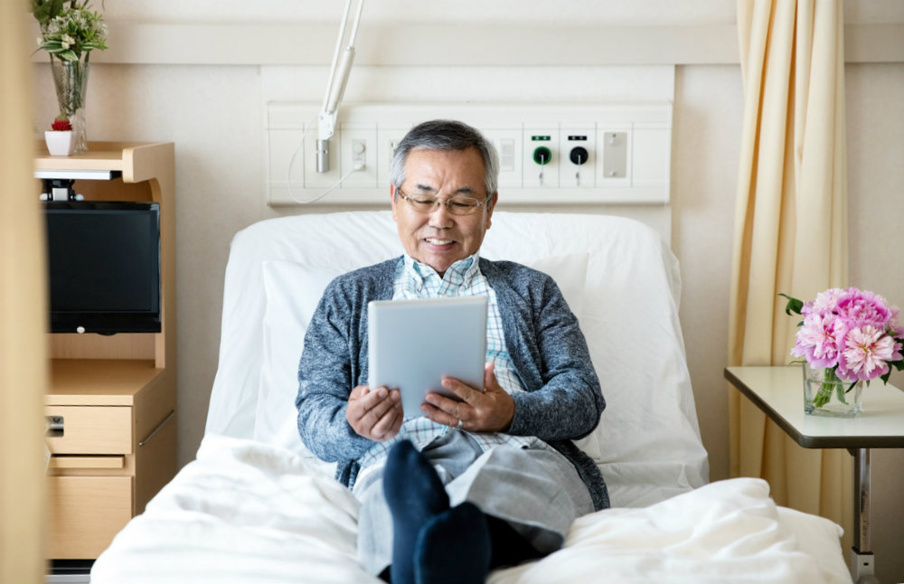 A patient relaxing on hospital bed reading