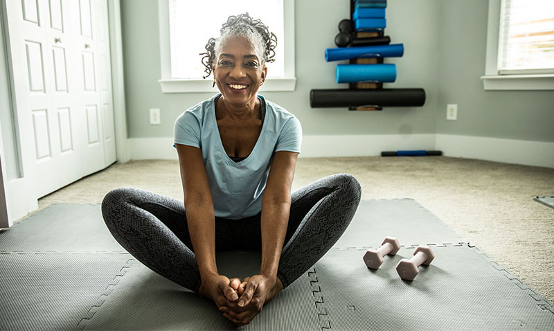 woman performing stretches on the floor at home