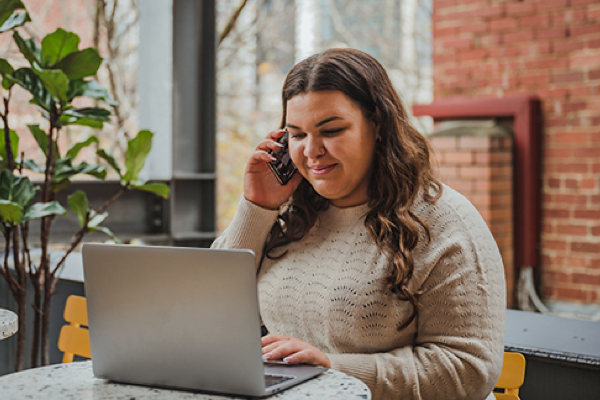 a woman talking on her mobile and working on the computer