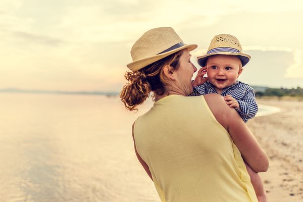 Mother walking on beach with son