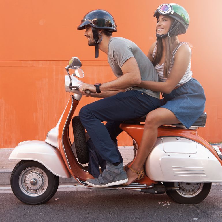A couple riding on scooter